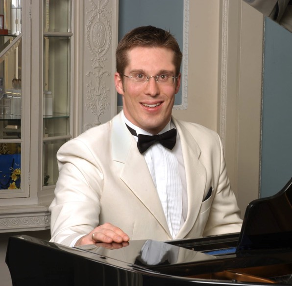 young man wearing shades and a hat with a beard, tattos and ear piercings